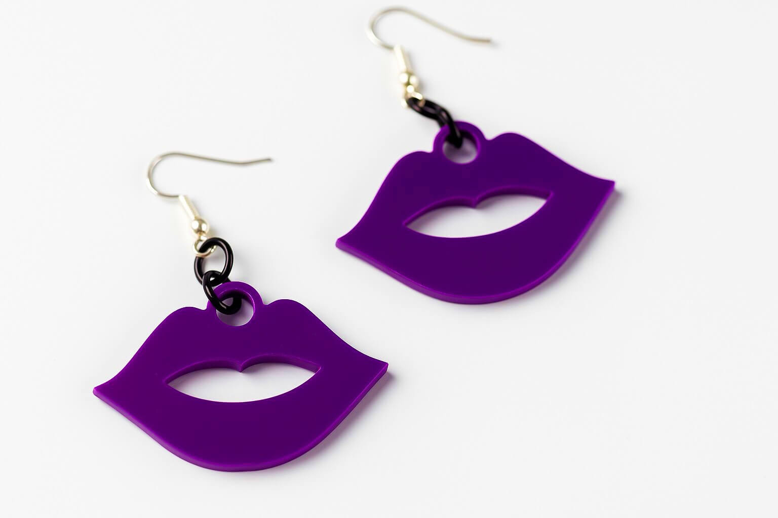 Purple heart-shaped earrings on a white background