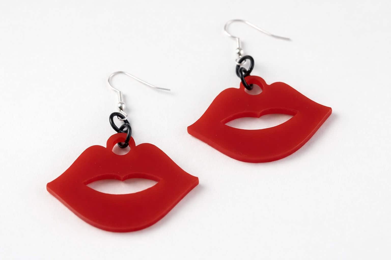 Red lips earrings on white background