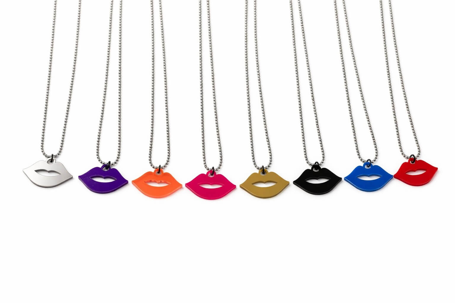 Row of colorful lip-shaped necklaces on white background