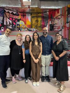 Wish I'd Known Connect group poses in front of colorful mural